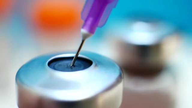 Hand holding syringe and medicine vial prepare for injection with surgical equipment and medicine vial background