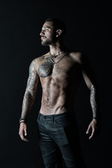 Tattooed man show sexy muscular torso. Sportsman with six pack and ab. Bodybuilder with biceps and...