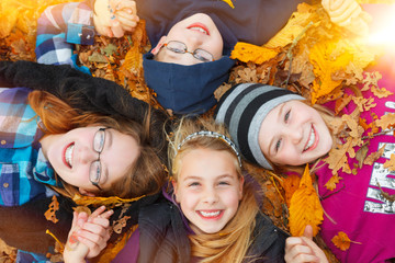 children outdoor on autumn leaves