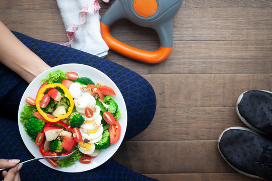 Fitness woman eating salad after workout, Healthy concept