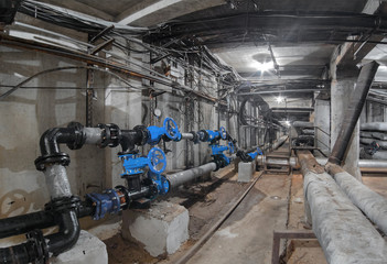 Blue valves on the water pipelines in an underground utility tunnel, heat pipeline and cable vault