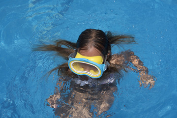 Kid in snorkel mask posing on poolside
