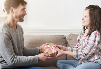 Loving father presenting gift to smiling daughter