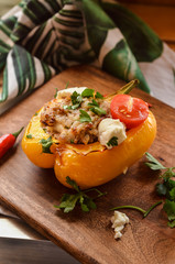 Stuffed pepper with meat and cheese on wooden board, background