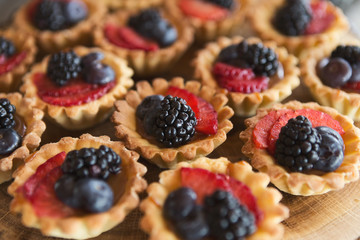 Berry tartlets dessert on wooden background