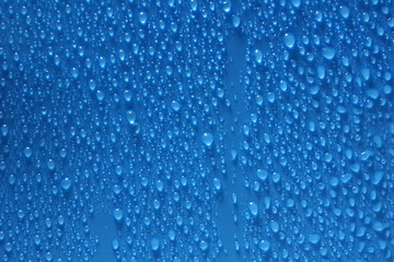 Naklejka na ściany i meble water drops blue color texture background close-up.