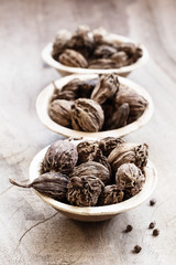 Fototapeta na wymiar Black cardamom whole seed in coconut bowl on wooden background indian spice