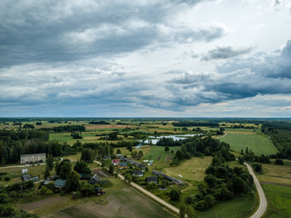 Obraz premium drone image. aerial view of rural area with houses and roads under heavy rain clouds