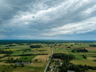 drone image. aerial view of rural area with houses and roads under heavy rain clouds