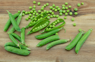 Fresh harvest green peas and pea pods from my garden on wooden  background