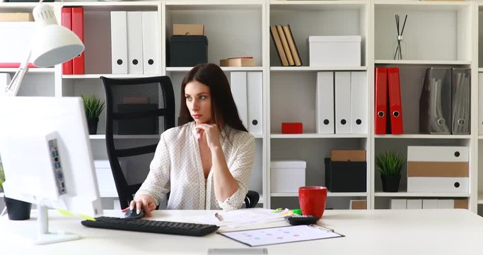 businesswoman in black skirt taking red folder off shelf.