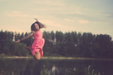 Tattooed Woman Jumping over the Lake