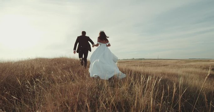Running through the landscape beautiful groom and bride.4k