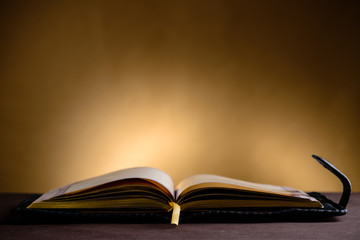 Still life with open old book on the wooden table