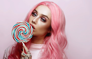 Beautiful young woman holding a lollipop 