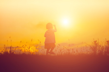 Fototapeta na wymiar kid silhouette,Moments of the child's joy. On the Nature sunset