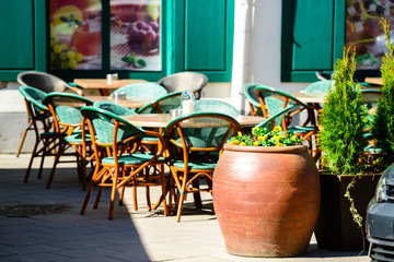 Street cafe or restaurant in the European city. Green chairs and
