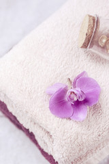 beautiful pink orchid on pale pink towel in spa salon.