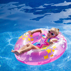little pretty girl is swimming in pool