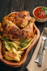 Roasted chicken legs with fried potatoes and tomato dip.