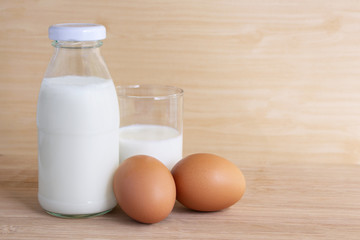 Bottle of milk and eggs on the wooden table.