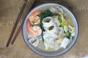Fried noodle with squid and shrimp, kale and soaked in gravy