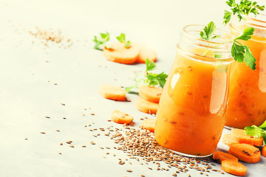 Carrot juice with flax seeds in glass bottles, healthy drink for raw diet, selective focus