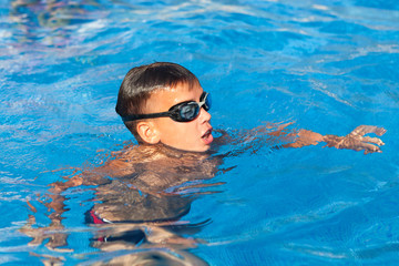 boy is swimming in pool, outdoor
