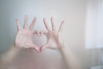 Female hands behind the glass in the bathroom.