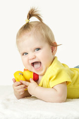 Fototapeta na wymiar Studio portrait of adorable baby girl playing with yellow rubber duck