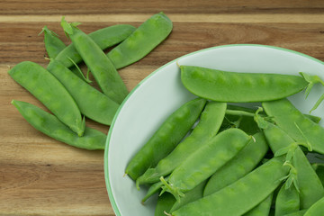 Fresh harvested Snow pea (Pisum sativum var. saccharatum) also known as mangetout organical grown in my garden isolated on wooden background