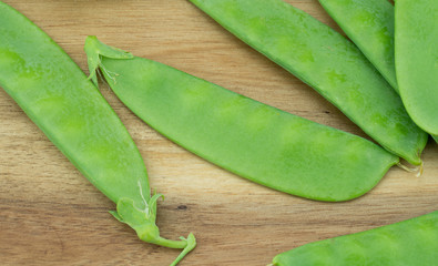 Fresh harvested Snow pea (Pisum sativum var. saccharatum) also known as mangetout organical grown in my garden isolated on wooden background