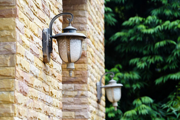 old outdoor wall lamp light on brick wall tree background
