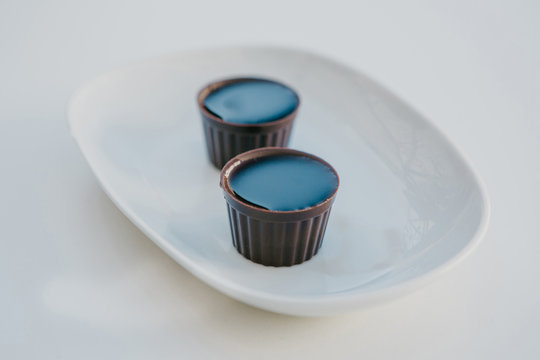 Two glasses made of chocolate in which traditional Portuguese liquor is poured named Ginjinha