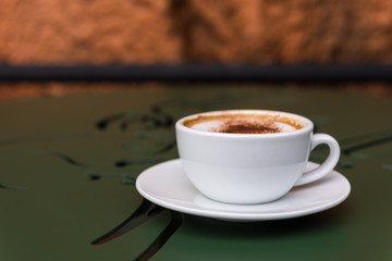 Cappuccino cup of coffee on green table