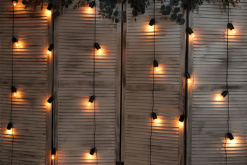 Glowing light bulbs hang on wires in a garland