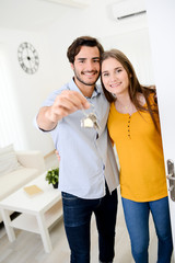cheerful young couple man and woman welcome friends at open front door new student home apartment