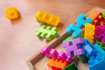 Toy colorful plastic blocks on wooden floor background