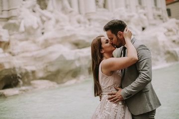 Naklejka premium Bride and groom posing in front of Trevi Fountain (Fontana di Trevi), Rome, Italy