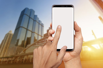 Hand holding blank screen smart phone with office buiding background