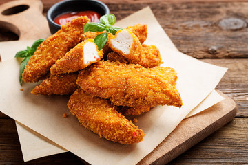 Delicious crispy fried breaded chicken breast strips with ketchup. - obrazy, fototapety, plakaty