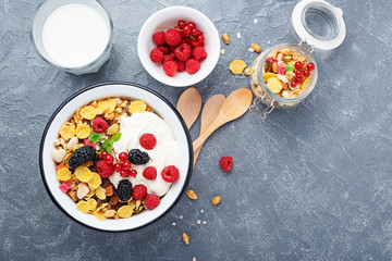 Healthy breakfast. Fresh granola, muesli with yogurt and berries on gray background. Top view. Copy space.