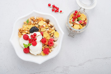 Healthy breakfast. Fresh granola, muesli with yogurt and berries on gray background. Top view. Copy space.