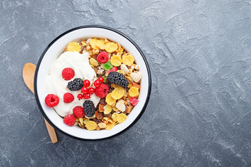 Healthy breakfast. Fresh granola, muesli with yogurt and berries on gray background. Top view. Copy space.