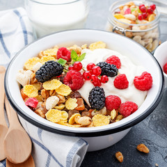 Healthy breakfast. Fresh granola, muesli with yogurt and berries on gray background. Top view. Copy space.