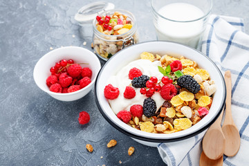 Healthy breakfast. Fresh granola, muesli with yogurt and berries on gray background. Top view. Copy space.