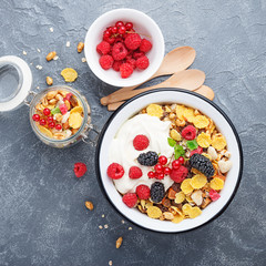 Healthy breakfast. Fresh granola, muesli with yogurt and berries on gray background. Top view. Copy space.