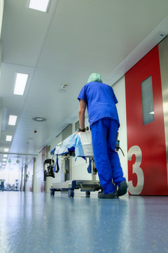 Male nurse pushing operation table