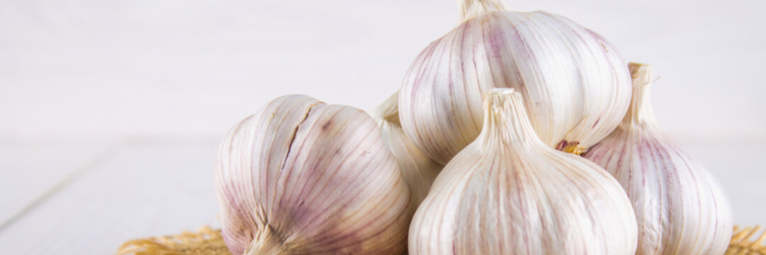 Garlic cloves and garlic bulb on a white wooden table