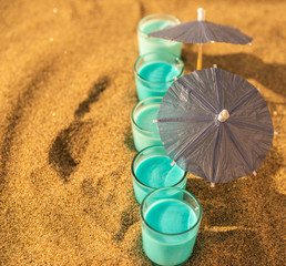 colorful shots drinks on a sandy beach with umbrellas for drinks